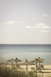 Spain, Formentera, Es Arenals, sunshades and beach chairs - CM000016