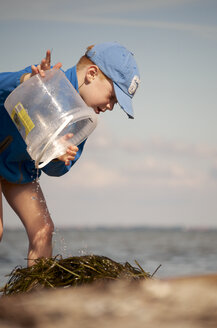 Germany, Schleswig-Holstein, Flensburg Fiord, Boy at beach with bucket - JEDF000038