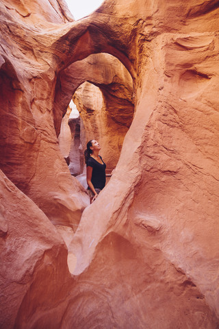 USA, Utah, Escalante, Peek-A-Boo und Spooky Slot Canyons, junge Frau betrachtet die Schönheit der Natur, lizenzfreies Stockfoto