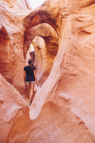 USA, Utah, Escalante, Peek-A-Boo und Spooky Slot Canyons, junge Frau betrachtet die Schönheit der Natur, lizenzfreies Stockfoto