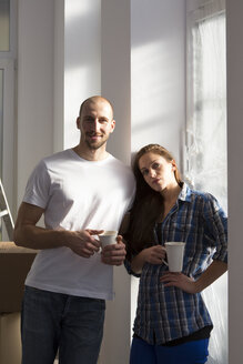 Junges Paar zieht in ein neues Haus ein und macht eine Kaffeepause - FKF000308