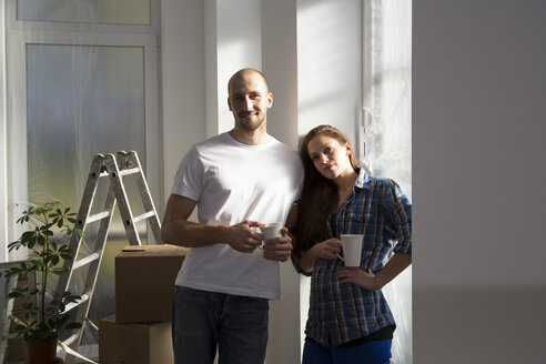 Junges Paar zieht in ein neues Haus ein und macht eine Kaffeepause - FKF000309