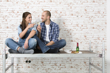 Junges Paar zieht in ein neues Haus ein und stößt mit Sektgläsern an - FKF000336
