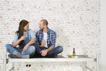 Junges Paar zieht in ein neues Haus ein und trinkt Champagner - FKF000337