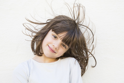 Porträt eines lächelnden kleinen Mädchens mit wehendem Haar, lizenzfreies Stockfoto