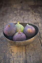 Bowl with four figs (Ficus carica) on wooden table, studio shot - LV000312