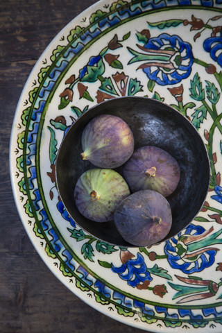 Schale mit vier Feigen (Ficus carica) auf traditionellem andalusischem Keramikteller, Studioaufnahme, lizenzfreies Stockfoto