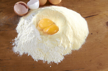 Wheat flower and semolina with egg yolk on pastry board - SRSF000389