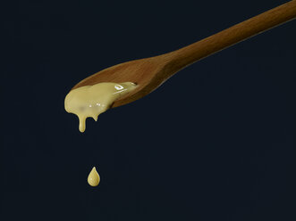 Vanilla sauce dripping from wooden spoon - SRSF000348