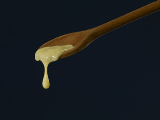 Vanilla sauce dripping from wooden spoon - SRSF000347