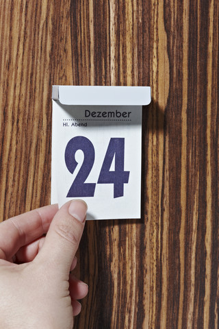 Hand tearing off calendar sheet of December 24th stock photo