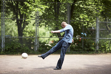 Fußballspieler, der den Ball auf dem Fußballplatz tritt - STKF000652