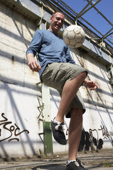 Man playing street soccer - STKF000679