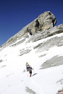 Österreich, Tirol, Karwendelgebirge, Bergsteiger überqueren Schneefeld - TKF000184