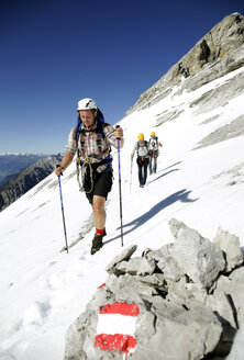 Österreich, Tirol, Karwendelgebirge, Bergsteiger überqueren Schneefeld - TKF000186