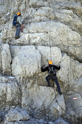 Austria, Tyrol, Karwendel mountains, Mountaineers climbing rockface - TKF000187