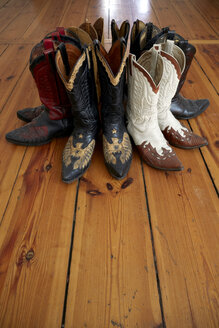 Germany, Berlin, Cowboy boots on wooden floor - TKF000204