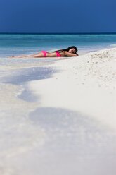 Malediven, Junge Frau im Bikini im flachen Wasser liegend - AMF001210