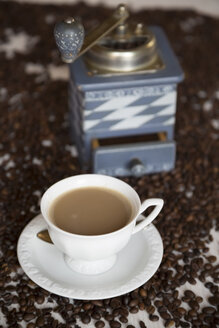 Tasse Kaffee, alte Kaffeemühle und Kaffeebohnen auf dem Tisch - SARF000134