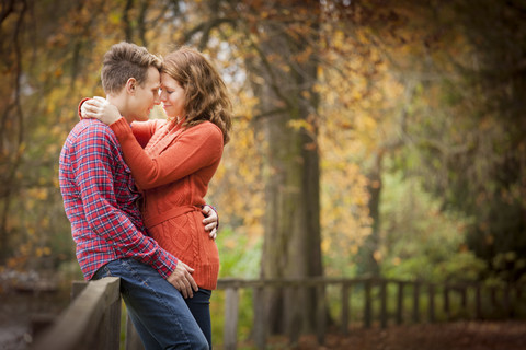 Glückliches junges Paar genießt den Herbst in einem Park, lizenzfreies Stockfoto