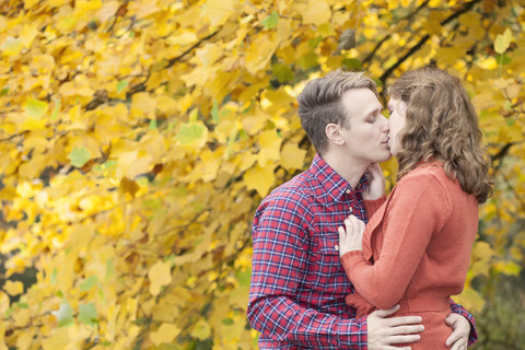 Happy young couple enjoying autumn in a park stock photo