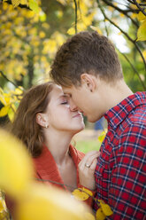 Glückliches junges Paar, das sich in einem Park küsst - BGF000028