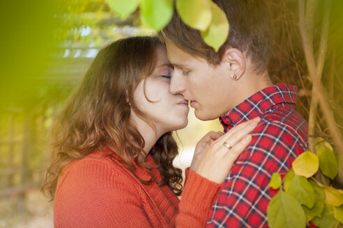 Happy young couple kissing in a park - BGF000025