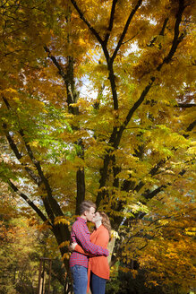 Glückliches junges Paar, das sich in einem Park küsst - BGF000026
