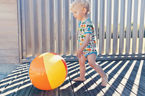 Kleiner Junge rennt nach Strandball, lizenzfreies Stockfoto