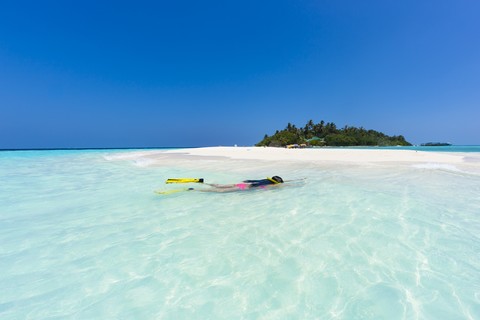 Malediven, junge Frau beim Schnorcheln in einer Lagune, lizenzfreies Stockfoto