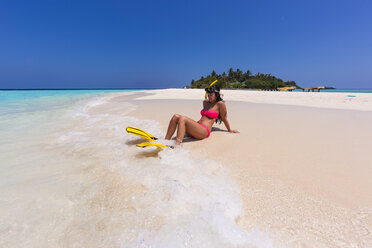 Maledives, young woman sitting at beach - AMF001225