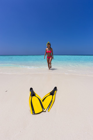 Maledives, young woman walking at beach stock photo