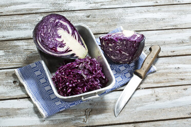 Rotkohl, Küchenmesser und Küchenhandtuch auf Holztisch - MAEF007341