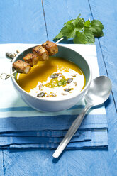 Creamed pumpkin soup in bowl with chicken skewer - MAEF007369