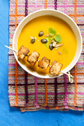 Creamed pumpkin soup in bowl with chicken skewer - MAEF007374