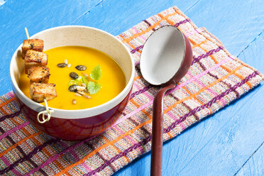 Creamed pumpkin soup in bowl with chicken skewer - MAEF007376
