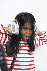 Porträt eines Mädchens, das mit Kopfhörern laute Musik hört - FSF000308