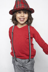 Porträt eines lächelnden kleinen Jungen mit Holzrassel, der Hut und Hosenträger trägt - FSF000312