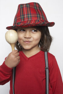 Porträt eines lächelnden kleinen Jungen mit Holzrassel, der Hut und Hosenträger trägt - FSF000313