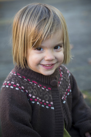Porträt eines lächelnden kleinen Mädchens mit Strickjacke, lizenzfreies Stockfoto