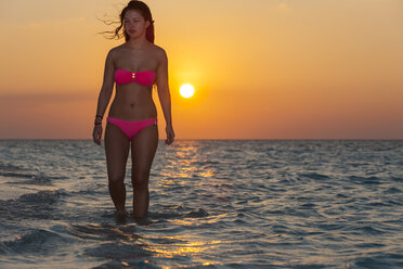 Malediven, junge Frau geht im Wasser - AMF001242