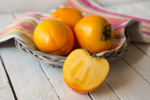 Kakifrüchte und geschnittene Kakifrüchte, lizenzfreies Stockfoto