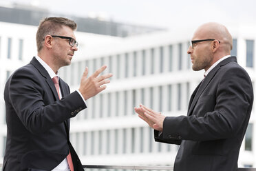 Poland, Warzawa, two businessmen gesturing - MLF000275