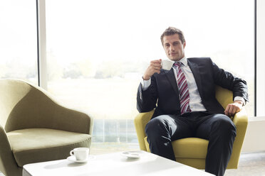 Poland, Warzawa, businessman having a coffee break at hotel lounge - MLF000284