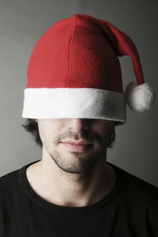 Junger Mann mit Weihnachtsmannmütze, Nahaufnahme, lizenzfreies Stockfoto