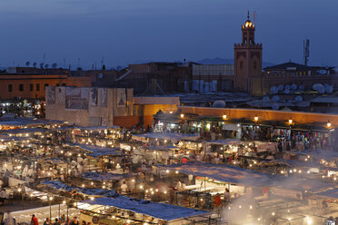 Marokko, Marrakesch, Menschen auf dem Djemaa el Fna Platz mit der Koutoubia Moschee bei Nacht - GF000308