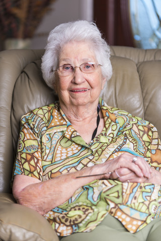 Ältere Frau in einem Sessel sitzend, lizenzfreies Stockfoto
