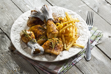 Chicken drums with french fries on plate - MAEF007390