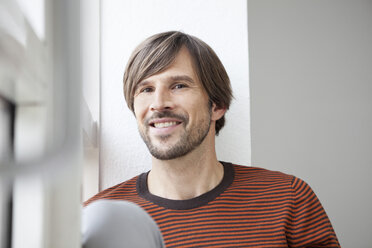 Deutschland, München, Mann sitzt am Fenster - RBF001409