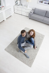 Germany, Munich, Couple sitting on floor in living room - RBF001431